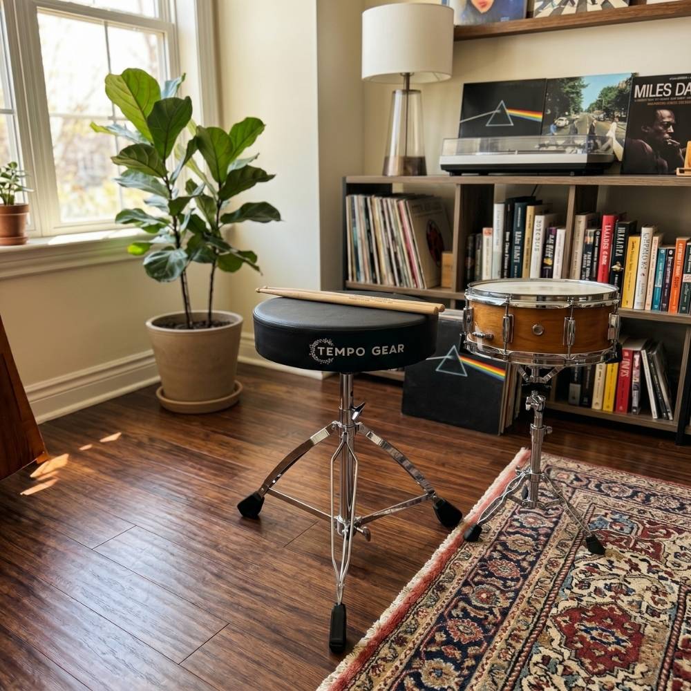 Drum stool on a stand in a room with books and a plant