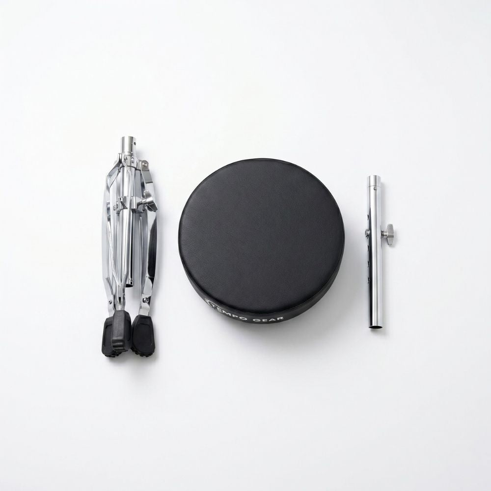 Set of drumming accessories including a black drum pad, two silver drumsticks on a white background